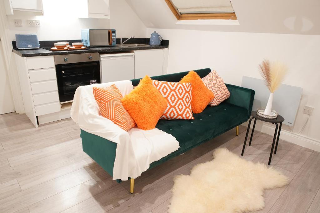 un divano verde con cuscini colorati in soggiorno di Peaceful Luxury Apartment a Croydon