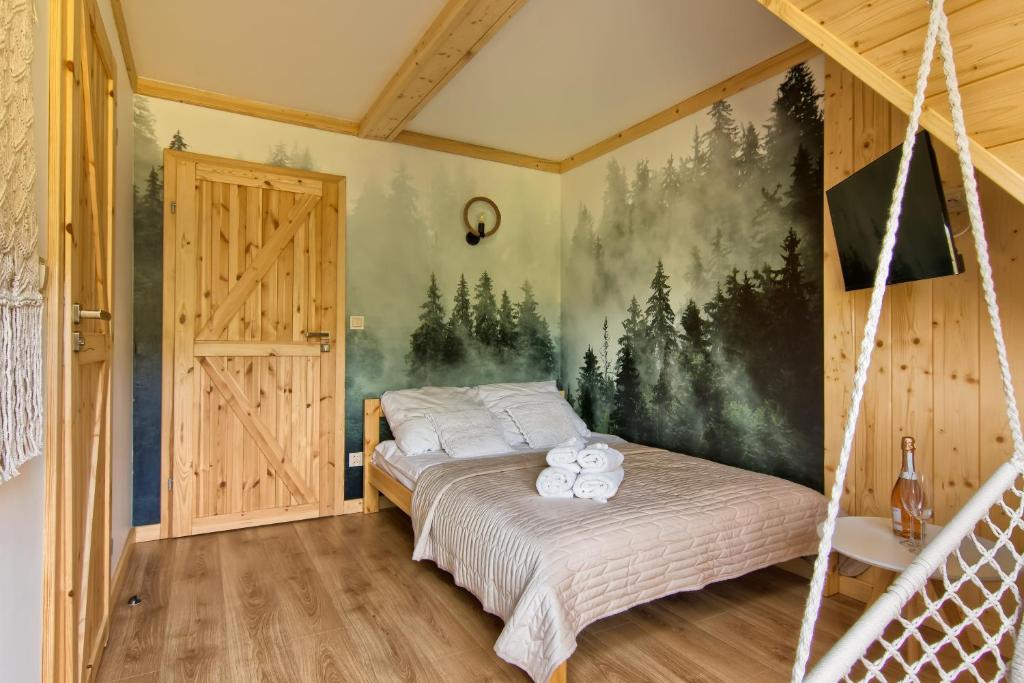 a bedroom with a bed with a painting on the wall at Apartamenty Kucovka 11 in Brzegi