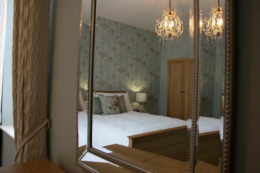 a mirror in a bedroom with a bed in it at Rooftops in Louth