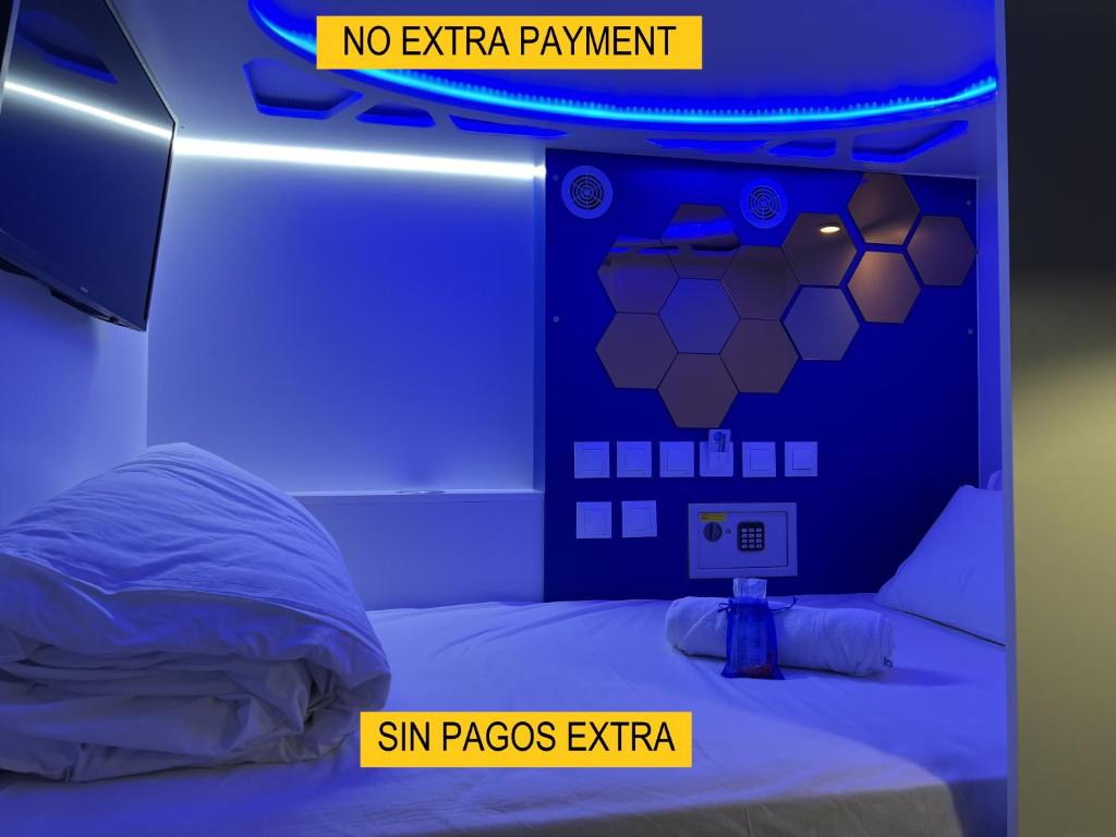 a room with a bed with a no extra payment sign at Modular Rooms in Madrid