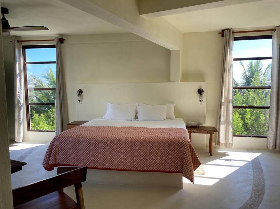 1 dormitorio con 1 cama grande y 2 ventanas en Casa Molly en Holbox Island