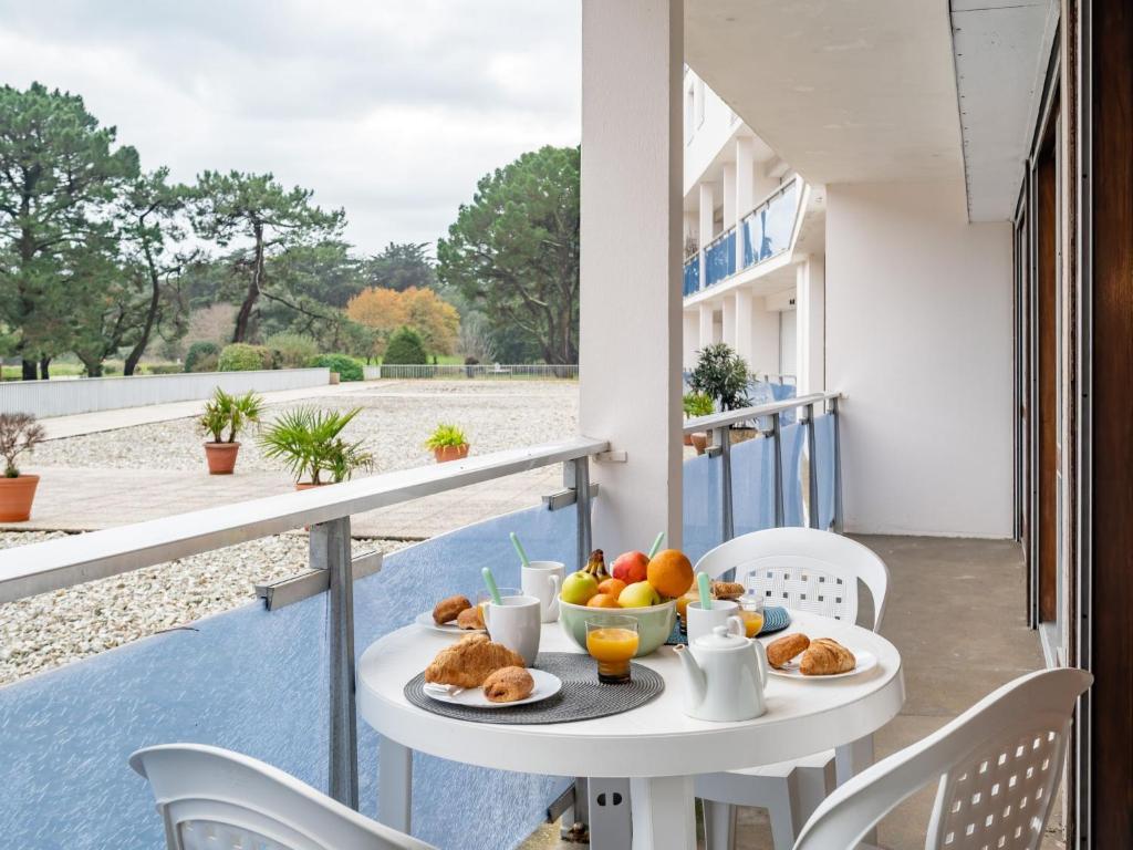 a table with breakfast food on a balcony at Apartment Men Er Bellec-1 by Interhome in Saint-Philibert
