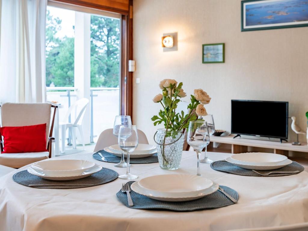 a dining room table with plates and wine glasses at Apartment Men Er Bellec-1 by Interhome in Saint-Philibert