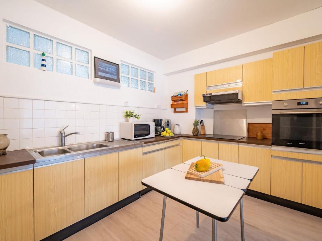 a kitchen with wooden cabinets and a table in it at Apartment Men Er Bellec-1 by Interhome in Saint-Philibert