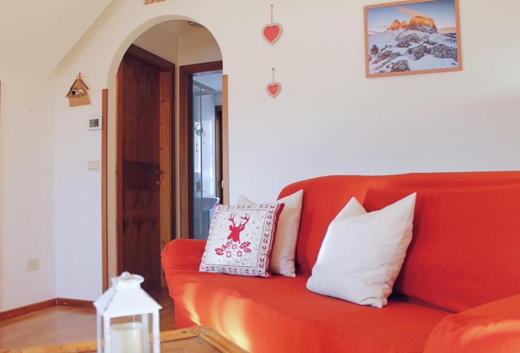 a red couch with pillows on it in a living room at CASA PARADISO - Vista valle in Cavalese