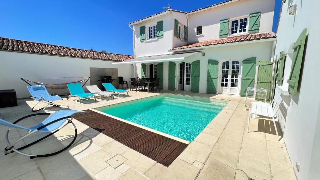 a swimming pool in the backyard of a house at Superbe villa d'architecte avec piscine chauffée in Loix