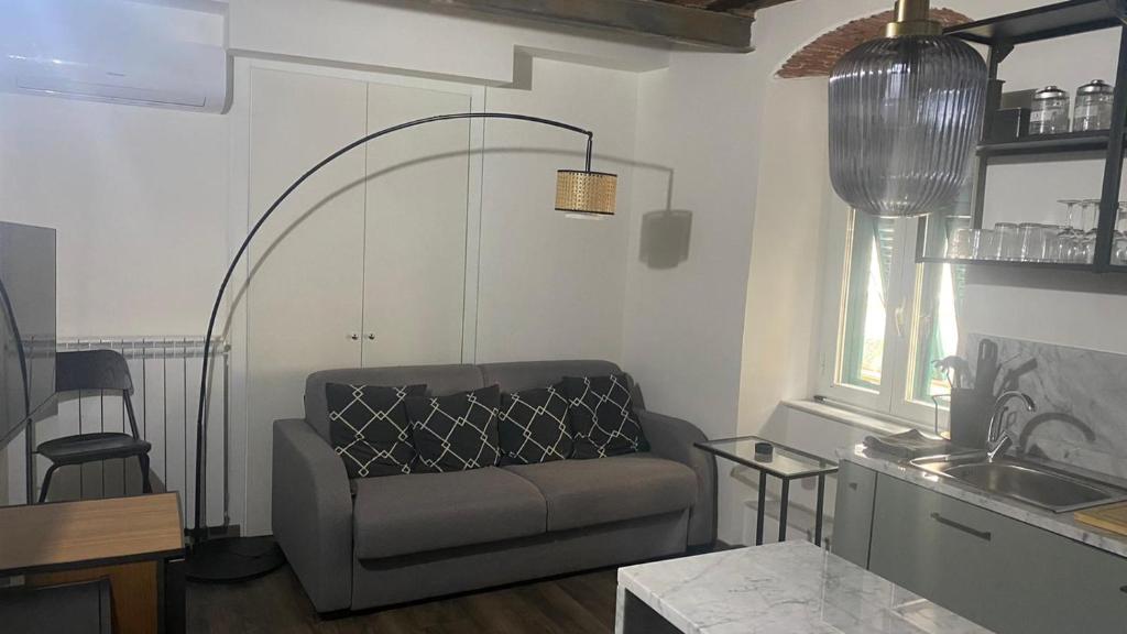 uma sala de estar com uma cadeira e uma cozinha em Stupendo bilocale nuovissimo con finiture di lusso em Carrara