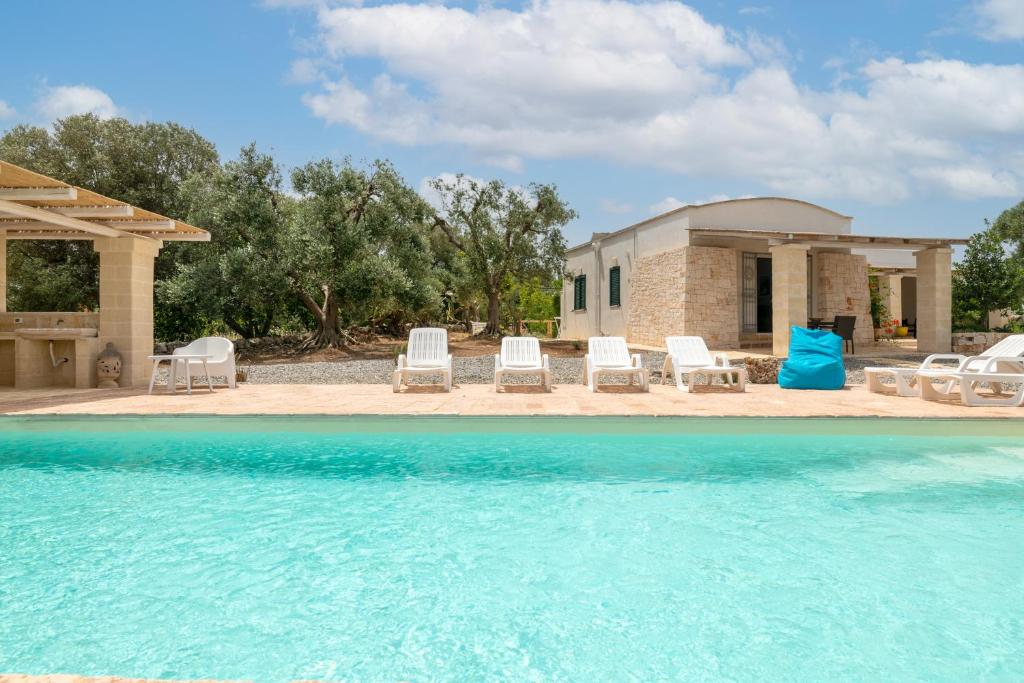 una casa con sedie e una piscina di Villa Philos a Ostuni