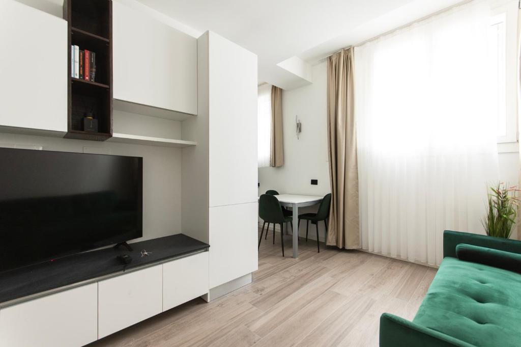 ein Wohnzimmer mit einem TV und einem Sofa in der Unterkunft YouHosty - Montebianco 4/6 in Mailand