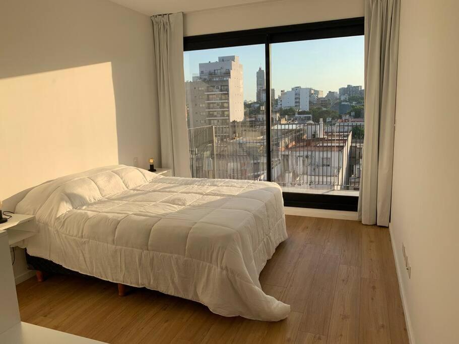 1 dormitorio con cama y ventana grande en Tu mejor espacio en Palermo en Buenos Aires