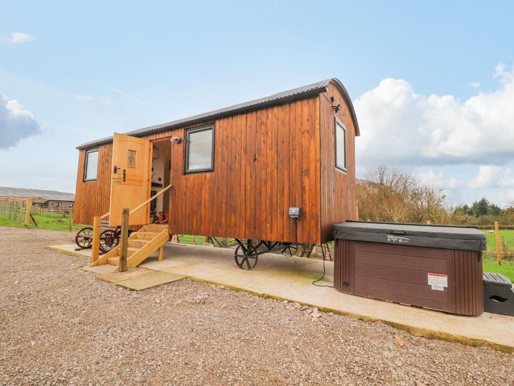 ein winziges Haus auf einem Wohnwagen mit einer Kiste in der Unterkunft Hillcrest Shepherds Hut in Preston