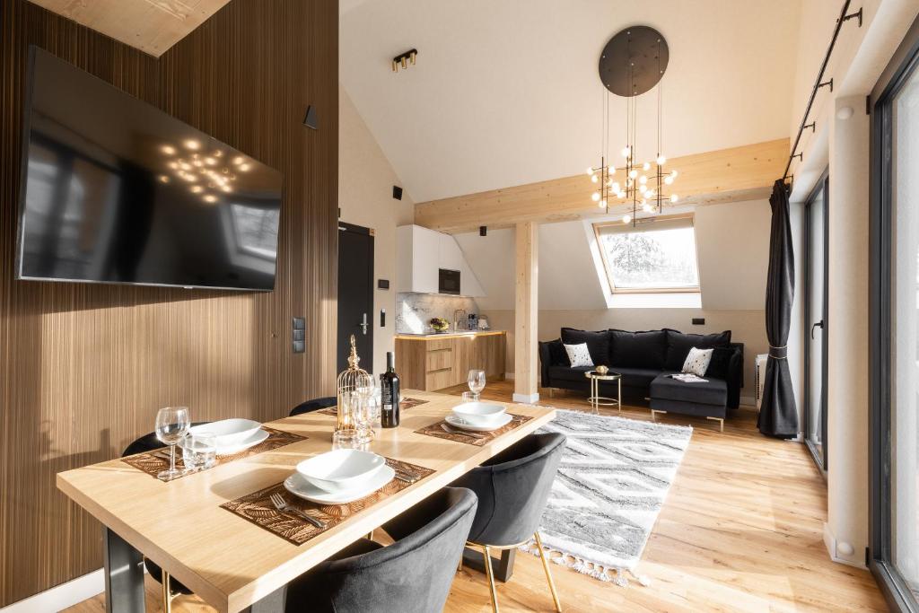 a dining room and living room with a table and chairs at Tatry Residence SPA in Kościelisko