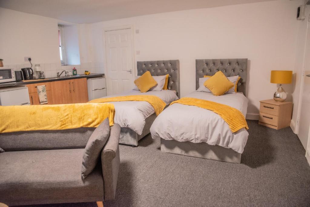 um quarto com duas camas e um sofá em Bv Comfy Basement 2 At Manningham Bradford em Bradford