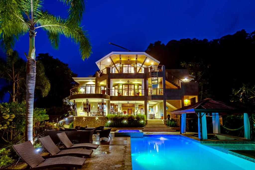 een huis met een zwembad in de nacht bij PUNTA GABRIELA in Dominical