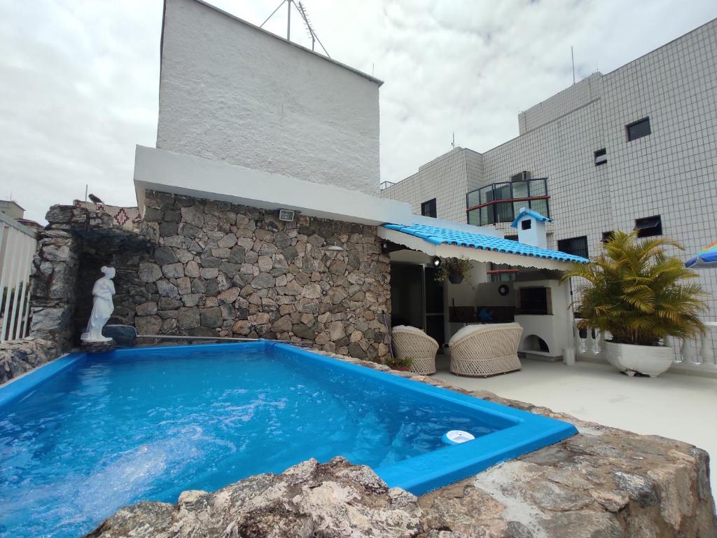 uma piscina em frente a um edifício em Cobertura Enseada Guarujá - 250 metros da praia no Guarujá