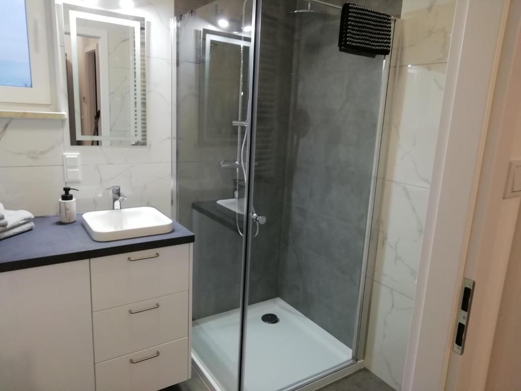 W łazience znajduje się prysznic i umywalka. w obiekcie Apartament MajaHouse w Nowej Soli