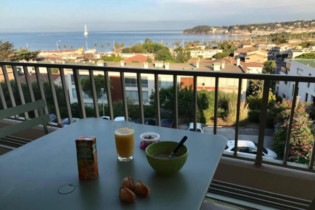 a table with a bowl of food and a drink on a balcony at Charming Studio With Terrace And 180 Sea View in Six-Fours-les-Plages
