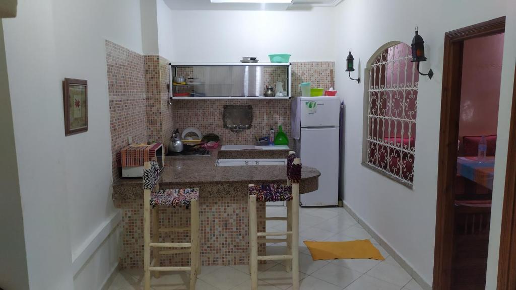 a small kitchen with a counter and a refrigerator at Studio Au Centre Ville Prés de la Medina in Fez