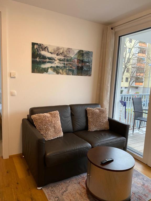 sala de estar con sofá de cuero y mesa en Modern apartment with balcony near city center, en Viena