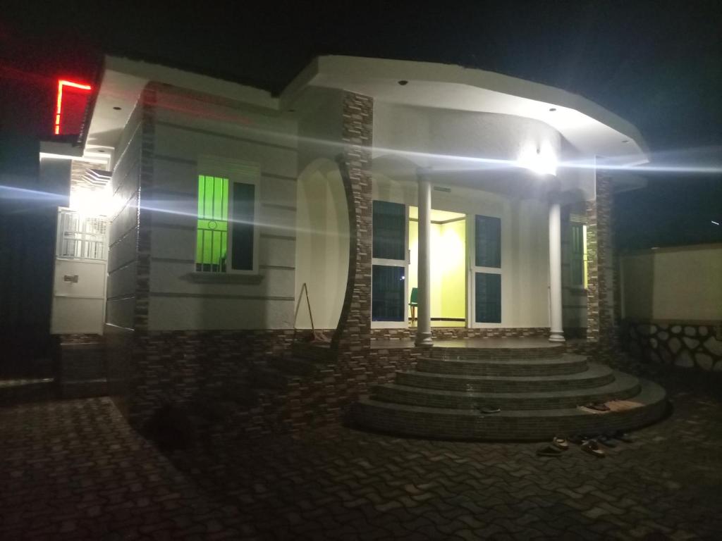 een huis met een groen licht aan de zijkant bij Pearl Motel Buloba in Buloba