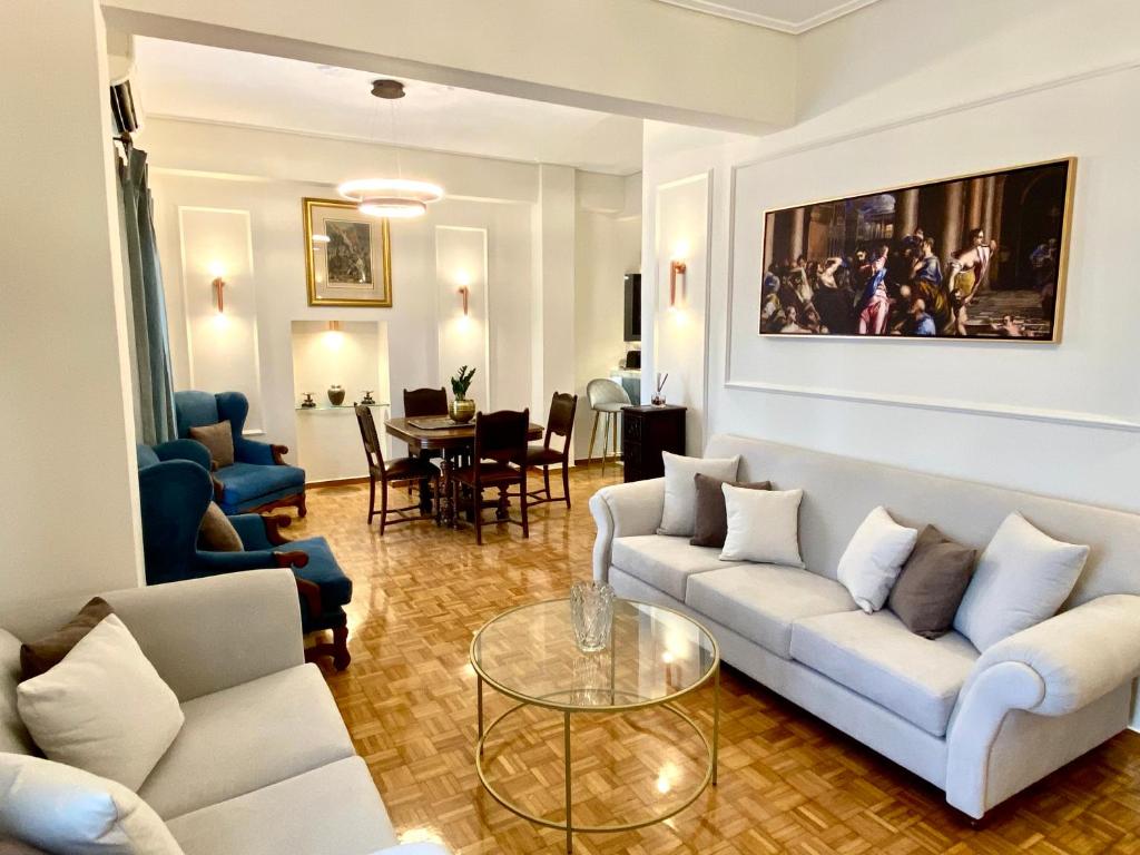a living room with white couches and a table at Athenian Condo in Athens