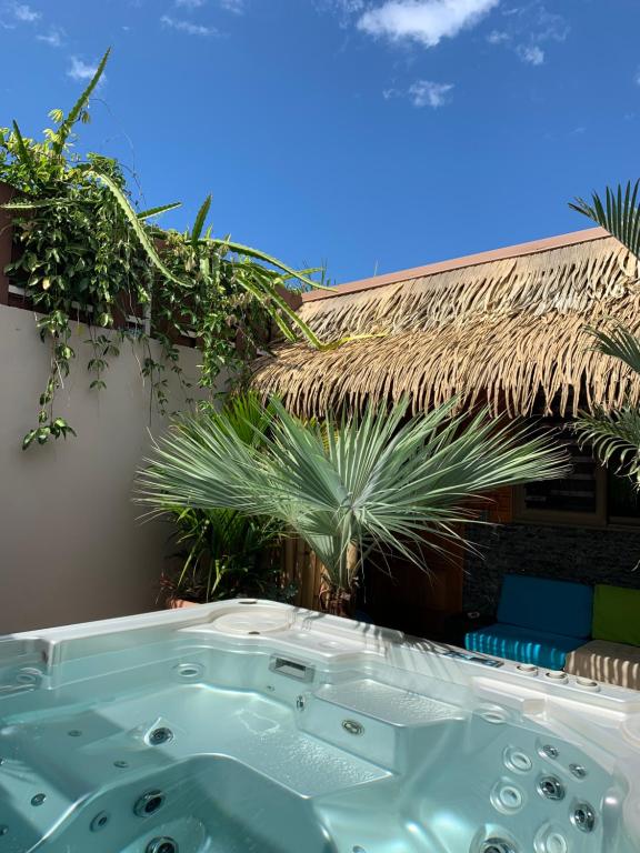 a jacuzzi tub in a yard with palm trees at TAMANU LODGE in Punaauia