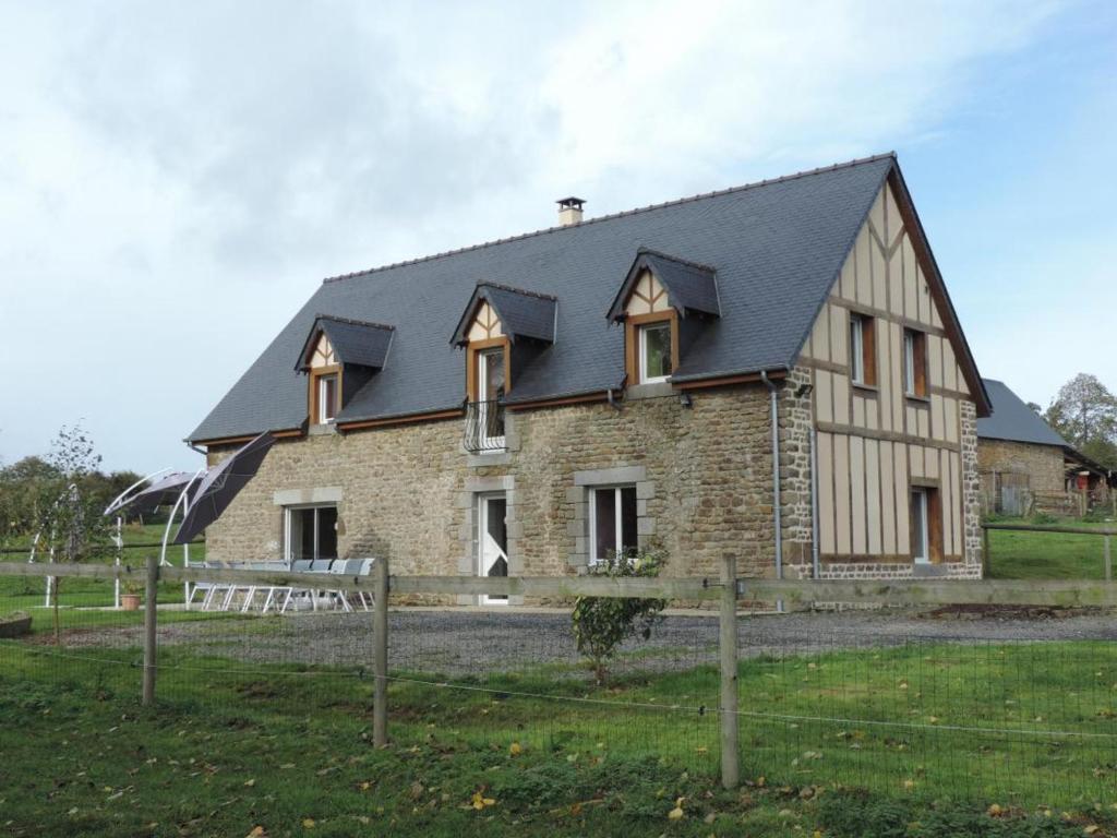 uma grande casa de pedra com um telhado preto em Gîte Landisacq, 6 pièces, 12 personnes - FR-1-497-167 em Landisacq
