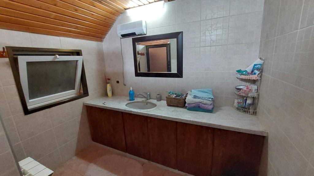 bagno con lavandino e specchio di אצל תיקי במושב a Sha'al