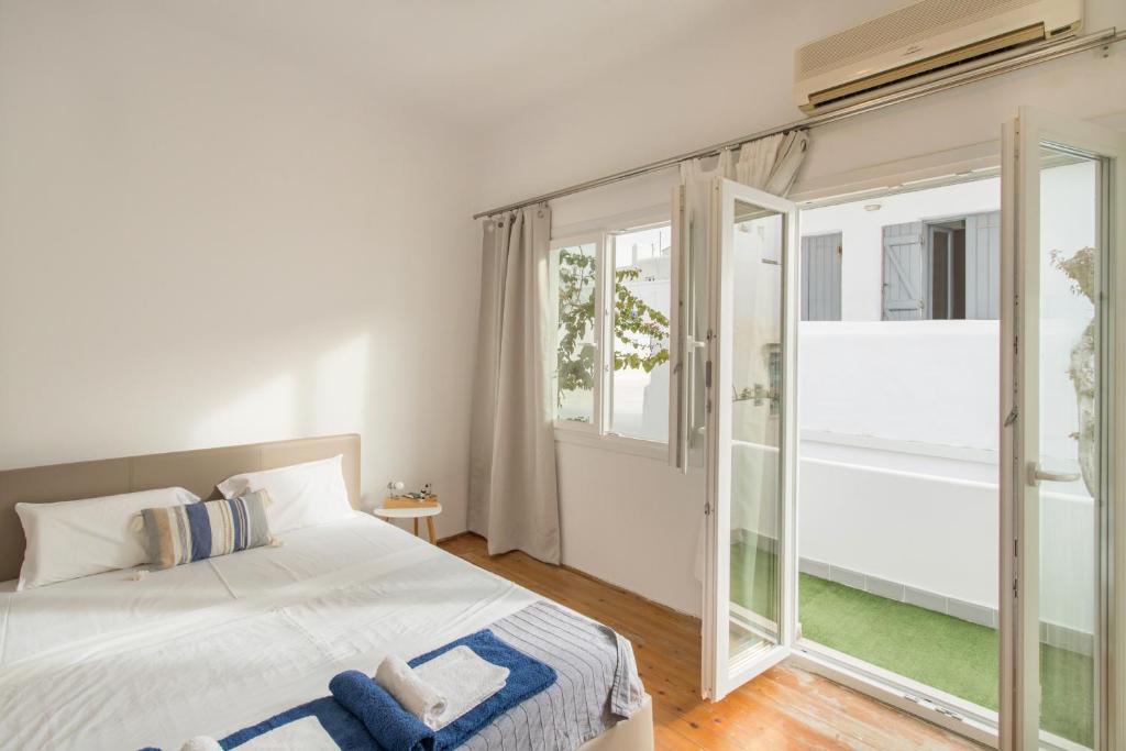 um quarto com uma cama e uma grande janela em Traditional Home em Naousa