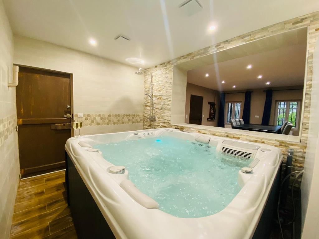 a large bath tub in a bathroom with at Un moment hors du temps - Jacuzzi - Sauna - Billard -Baby-Foot- Parking - 167 in Rouen