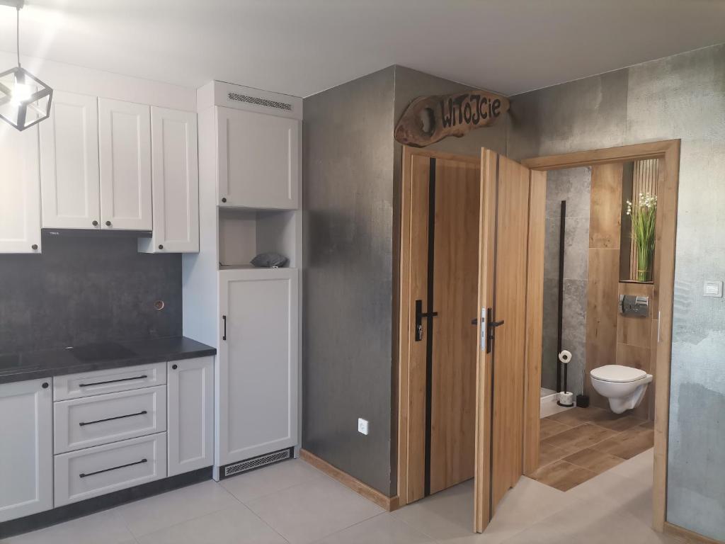 a kitchen with a door leading to a bathroom at Apartament Górska Szarotka in Nowy Targ