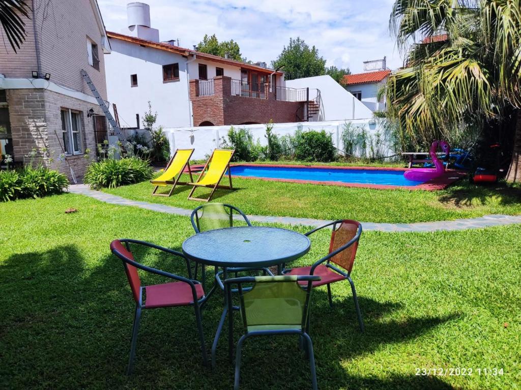 una mesa y sillas en un patio con piscina en hostel olivos in 