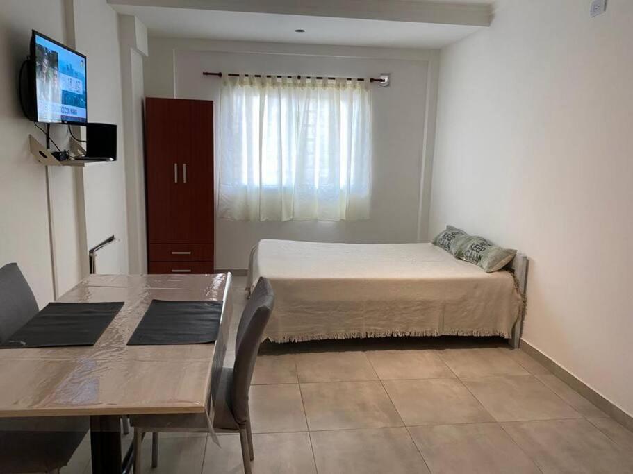 1 dormitorio con cama, mesa y TV en Alojamiento Terrada departamento completo en Villa Pueyrredón en Buenos Aires