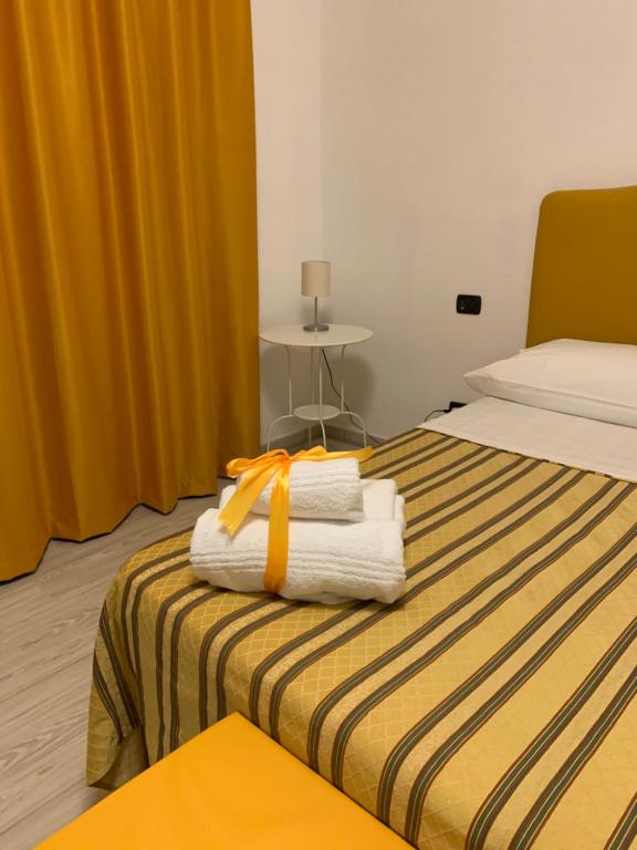 una camera d'albergo con un letto e asciugamani di B&B San Pietro Book sharing a Nola