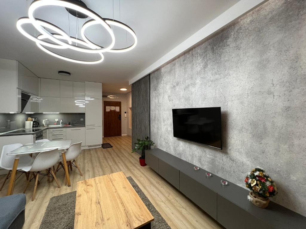 una cucina e un soggiorno con tavolo e TV di Solna Apartament PREMIUM a Kołobrzeg