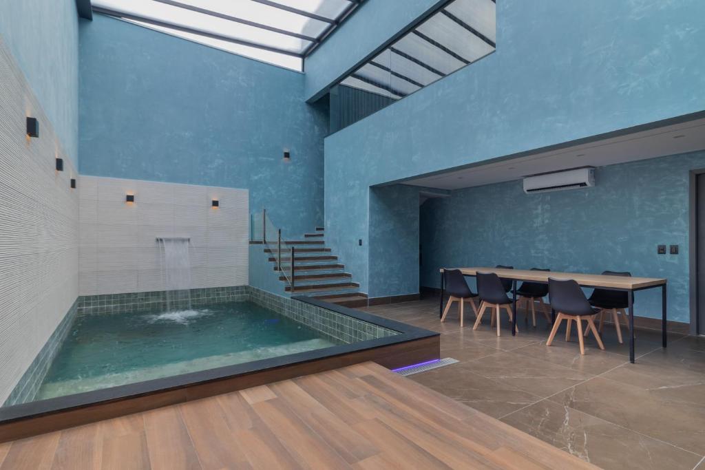 a swimming pool with a table and chairs in a room at Drops Vale dos Sinos in Ararica