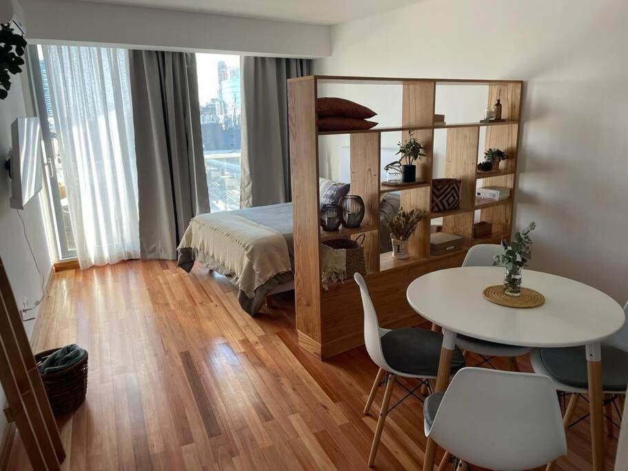 een slaapkamer met een bed, een tafel en stoelen bij Moderno departamento Palermo vista La Rural in Buenos Aires