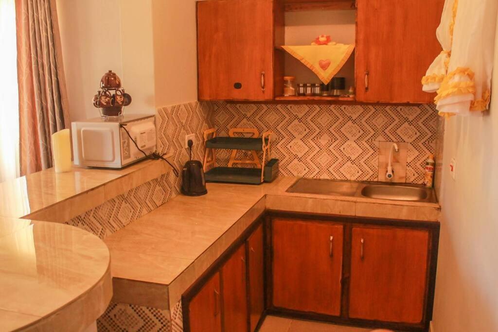 a kitchen with a sink and a microwave at Little Heaven's Home, 1 bedroom cozy home in Malindi