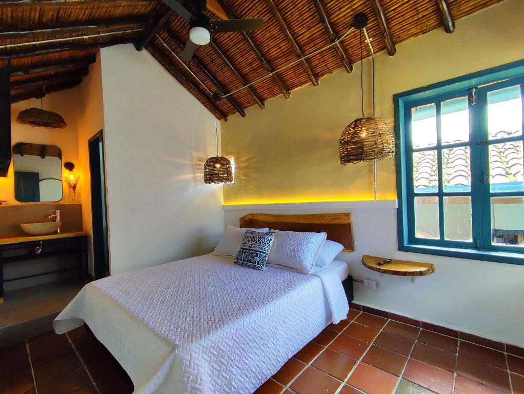 a bedroom with a white bed and a window at Trip Monkey Girón in Girón