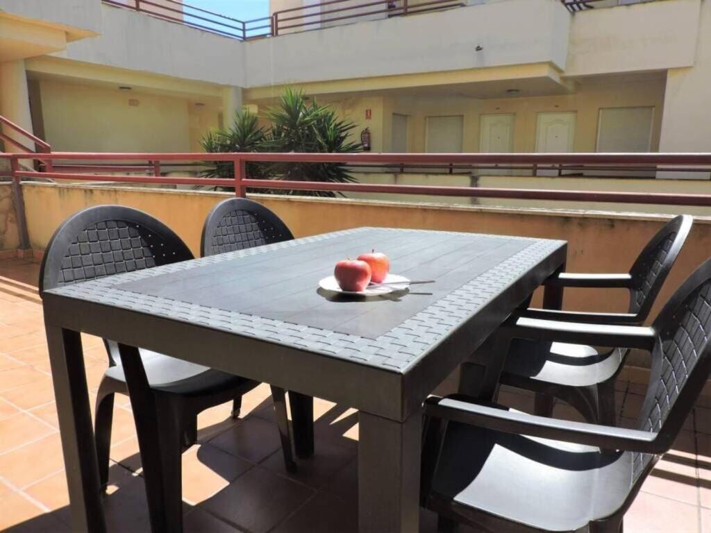 a table and chairs with a plate of fruit on it at Apartment with terrace and pool by the sea in Los Caños de Meca