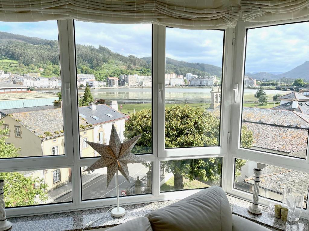 a living room with a large window with views of a river at The Cliffs - Passion Eccehomo in Viveiro
