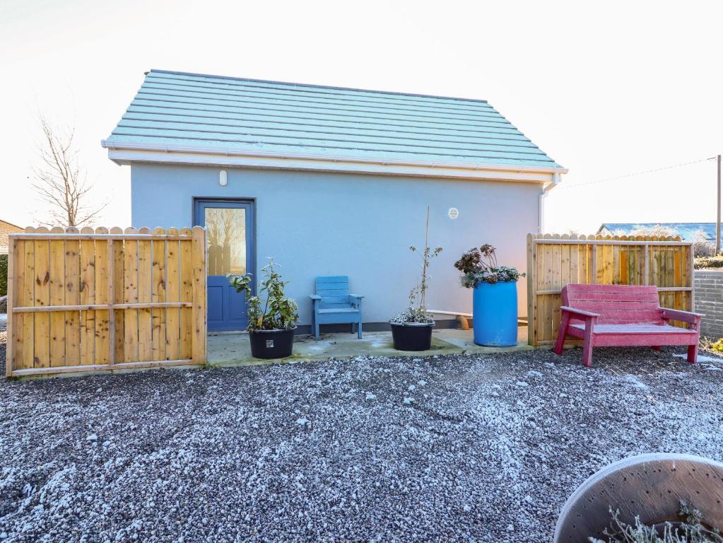 a blue house with a bench and two chairs at Mountain View in Kinvara