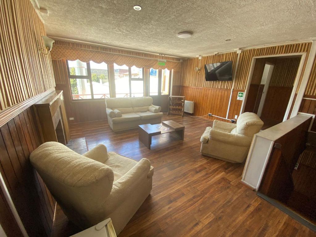 uma sala de estar com dois sofás e uma televisão em Hostal Ochen em Punta Arenas