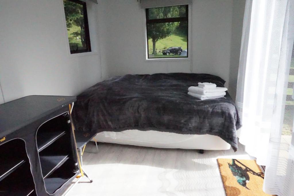 納爾遜的住宿－Cable Bay Farm，一间卧室配有一张带黑色毯子的床