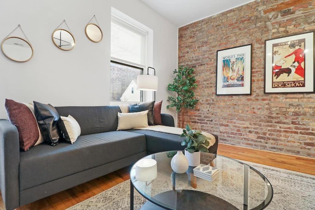 a living room with a couch and a brick wall at Modern 4BR Pilsen Apt near Restaurants - Racine 202 in Chicago
