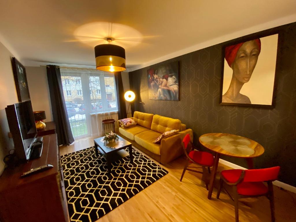 uma sala de estar com um sofá e uma mesa em Apartament Golden Studio em Mielec