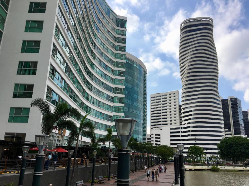 a tall building next to a river with buildings at Apartments Puerto Santa Ana in Guayaquil