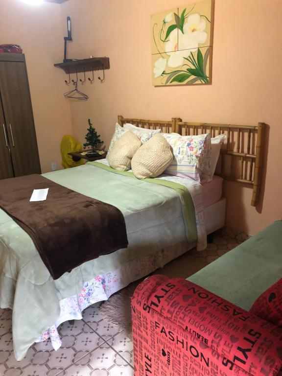 ein Schlafzimmer mit einem Bett und einer Ottomane in der Unterkunft Cantinho da Paz in São Pedro da Serra