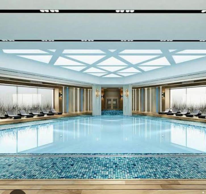 a large swimming pool in a building with chairs at Superb residence,pool,gym,sauna in Istanbul