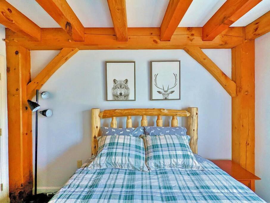 ein Schlafzimmer mit einem Bett mit einer karierten Decke in der Unterkunft Newly Renovated & Furnished Condo, Only 3 min to Sunday River! in Bethel